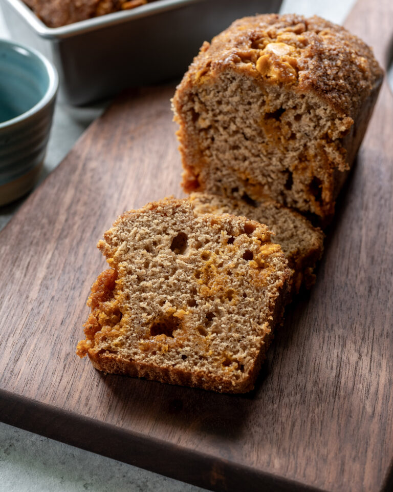 Apple butter quick bread sliced on a cutting board, with two slices stacked.