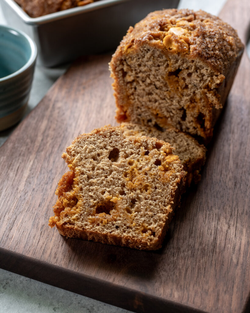 Apple butter quick bread sliced on a cutting board, with two slices stacked.