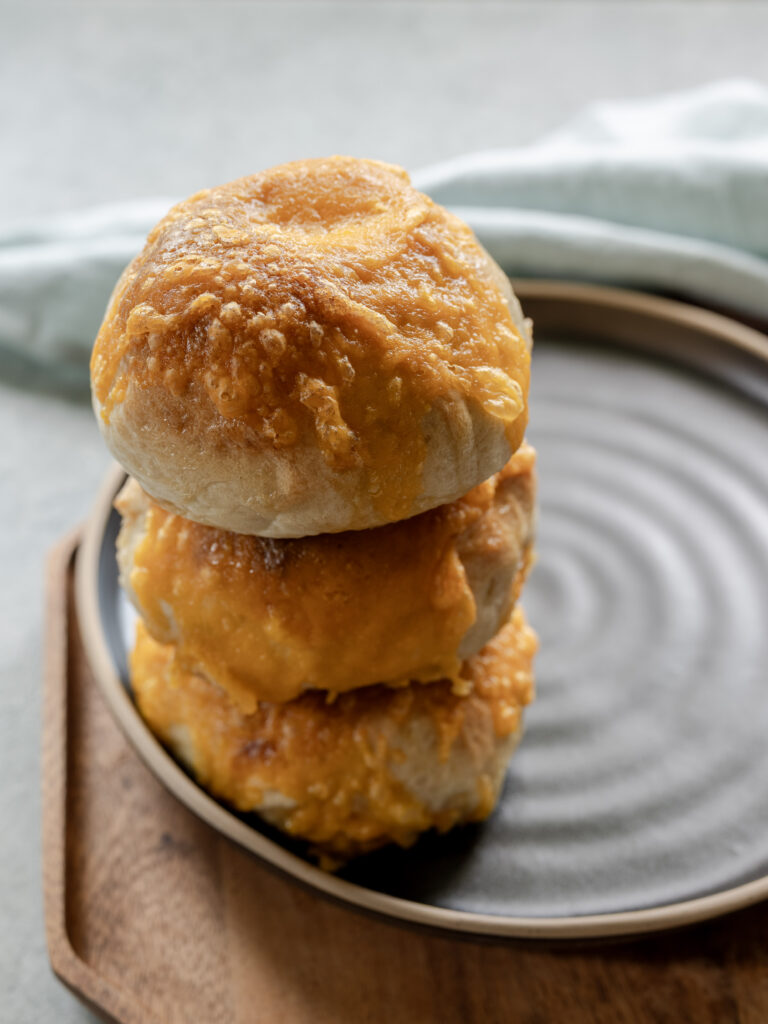Pickled pepper and cheddar sourdough bagels made with beer and stacked on a plate